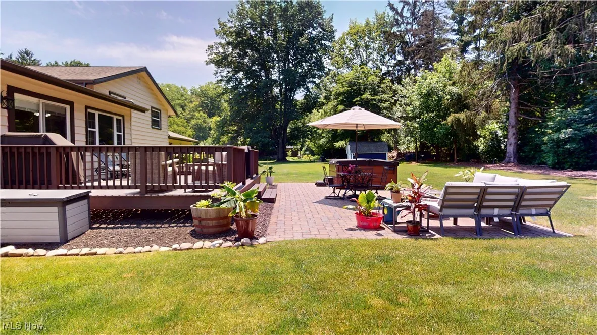 View of grassy yard with a deck and a patio