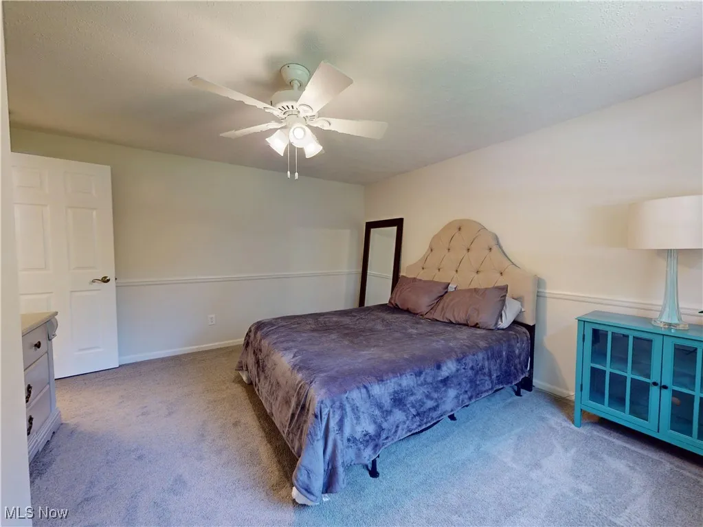 Carpeted bedroom featuring baseboards and ceiling fan