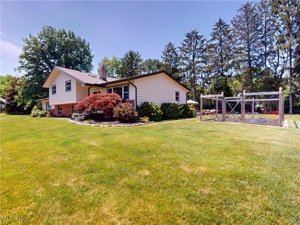 View of home's exterior featuring a chimney, a lawn, and brick siding