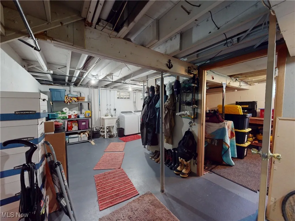 Unfinished below grade area featuring independent washer and dryer and a sink