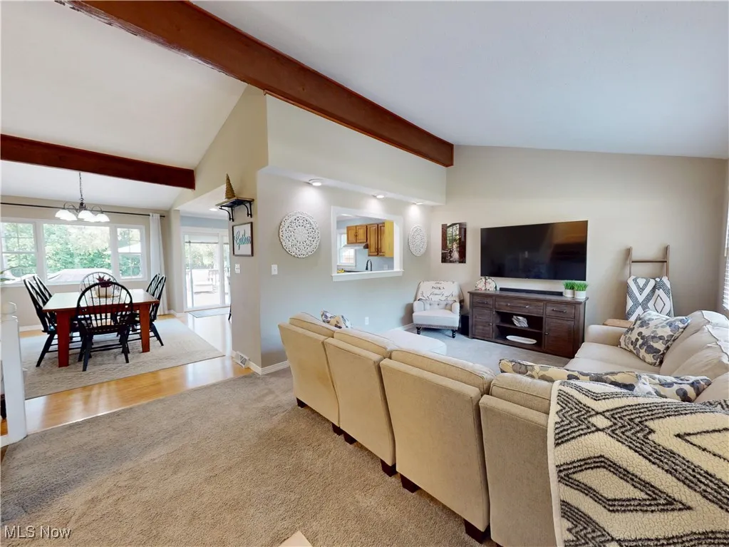 Living room with light colored carpet and a chandelier