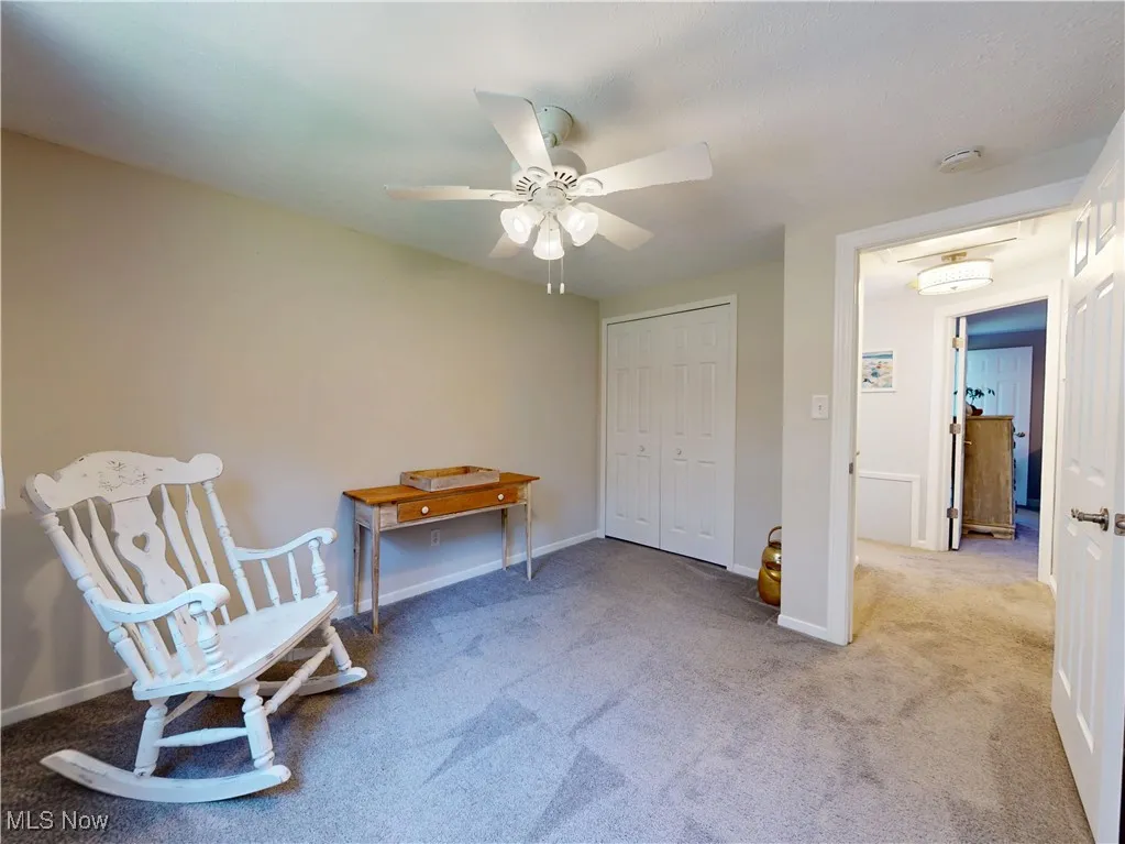 Sitting room with carpet flooring and a ceiling fan