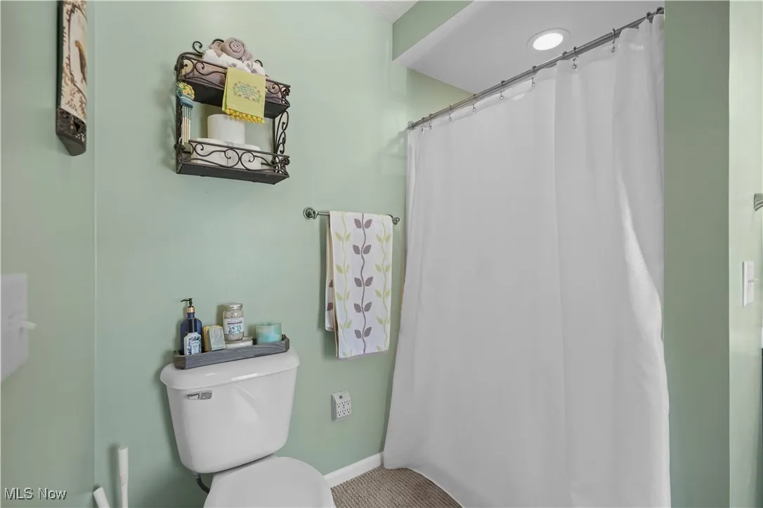 Bathroom with toilet and a shower with curtain
