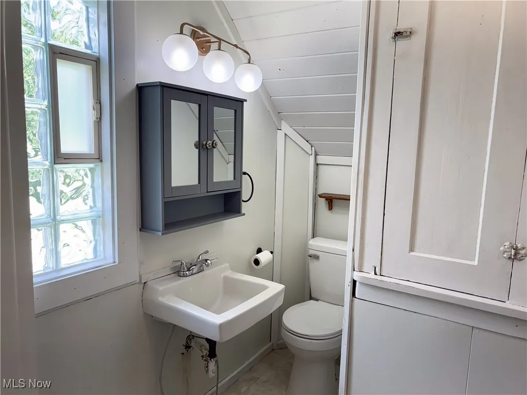 Bathroom with vaulted ceiling, healthy amount of natural light, wood ceiling, and tile patterned floors