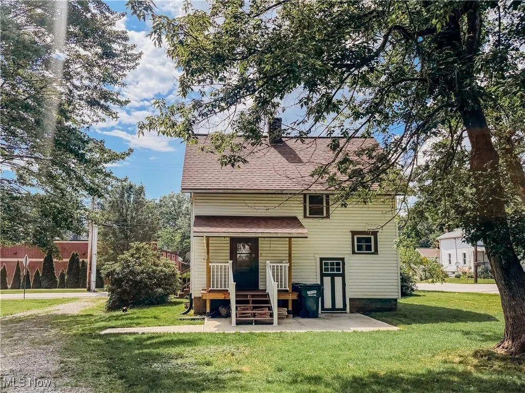 Back of house with a yard and a shingled roof