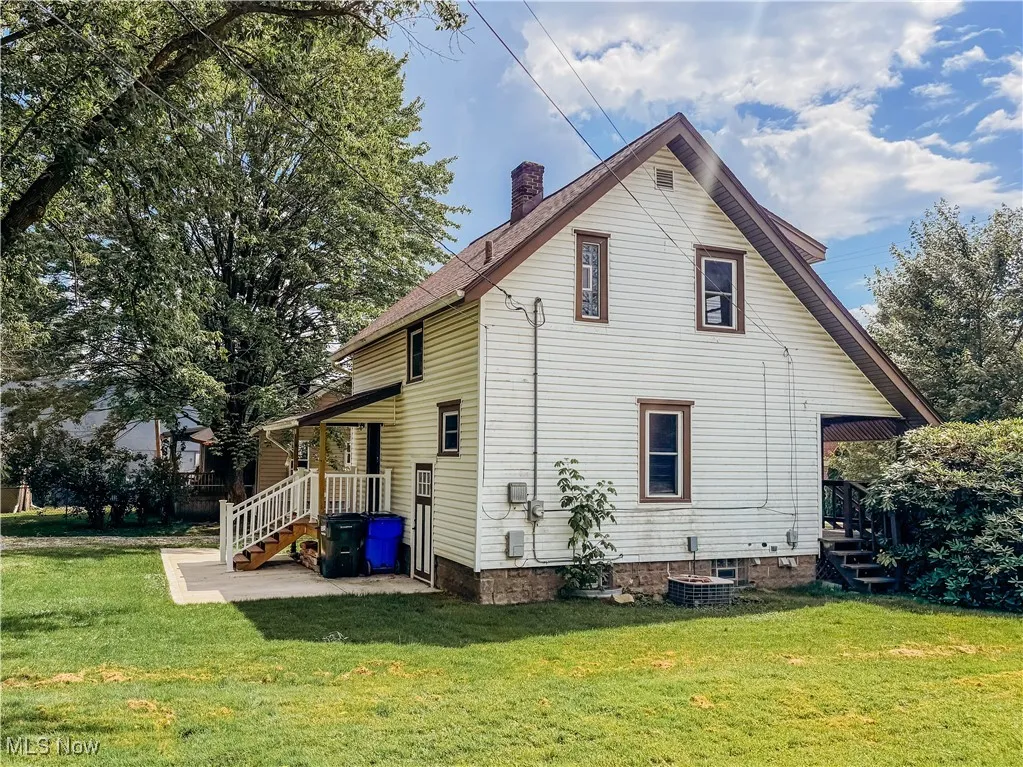 Back of property featuring a lawn and a chimney