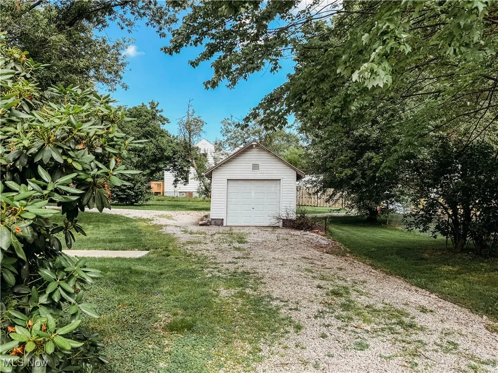 View of grassy yard, a garage, and driveway