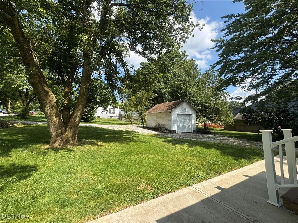 View of green lawn featuring a garage