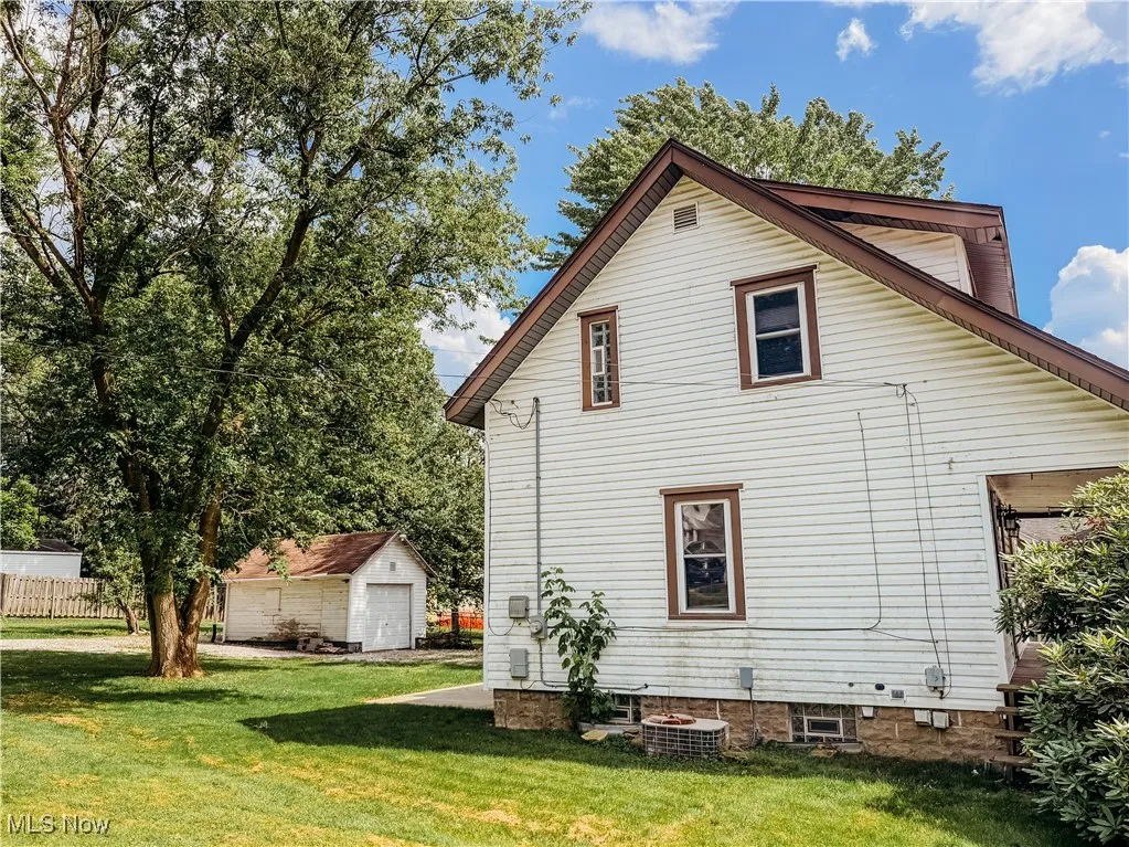 View of side of home featuring a yard, a garage
