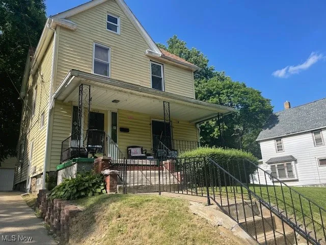 View of front facade with covered porch, stairway, and a front yard