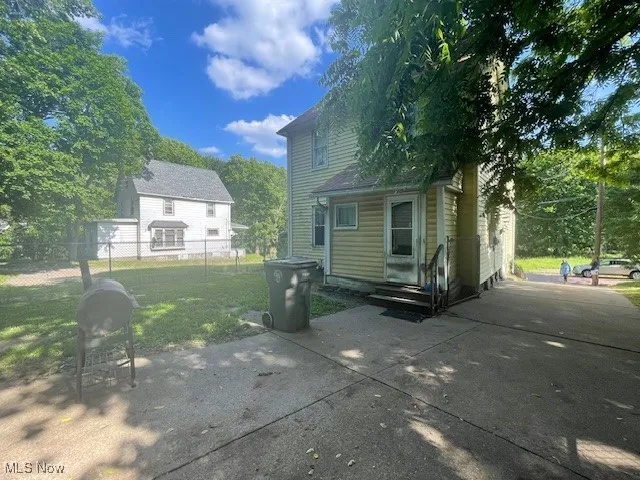 Rear view of house with driveway and a patio area