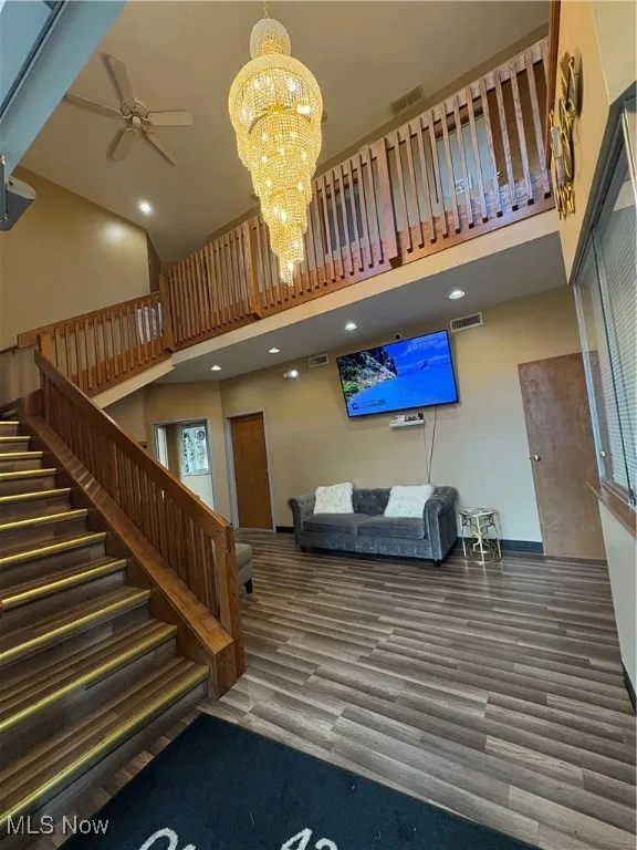 Lobby with high vaulted ceiling, stairway, and recessed lighting