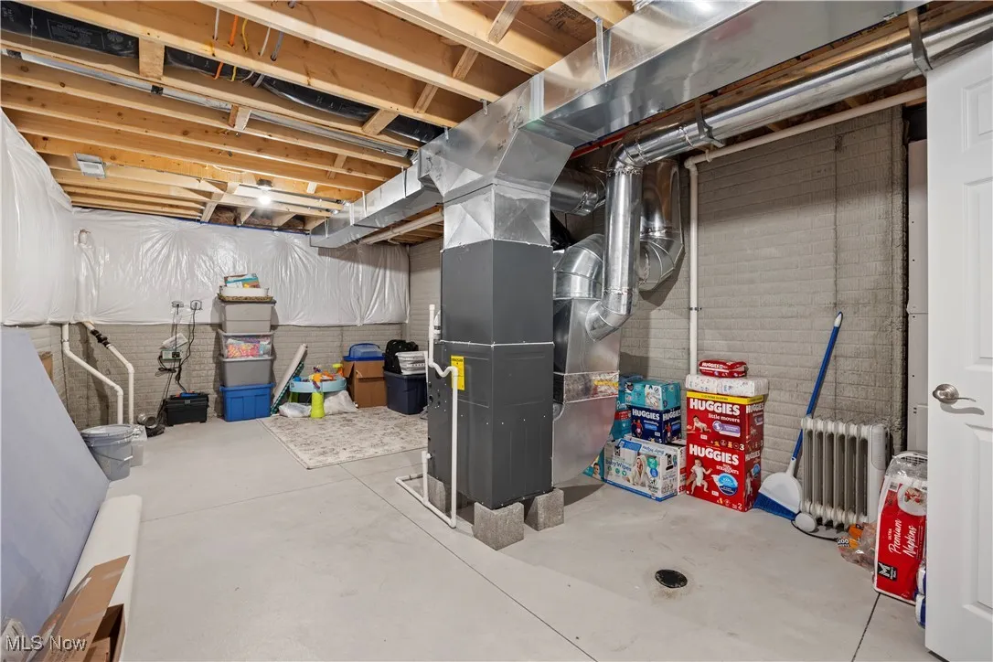 Storage area in basement by furnace and water heater with a slop sink
