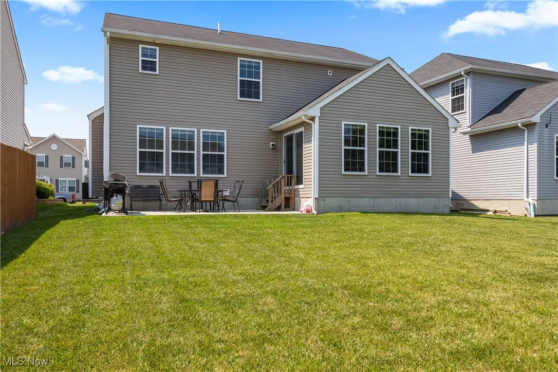 Back of home showing the yard, patio and entry steps
