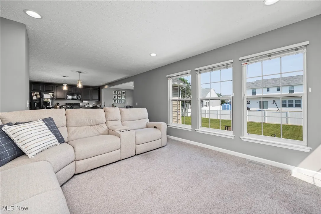 View of the living room area, from fireplace end, loads of natural lighting shows seamless transition throughout main floor for entertaining and family gatherings