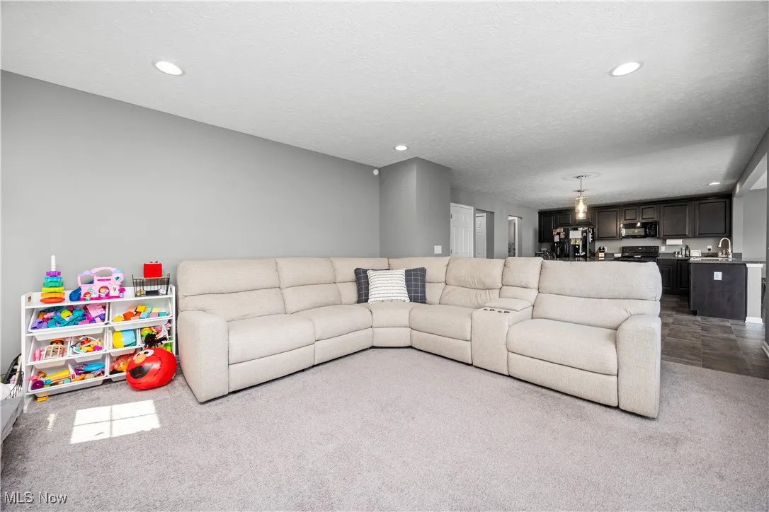 View of the living room area, from fireplace end, loads of natural lighting shows seamless transition throughout main floor for entertaining and family gatherings