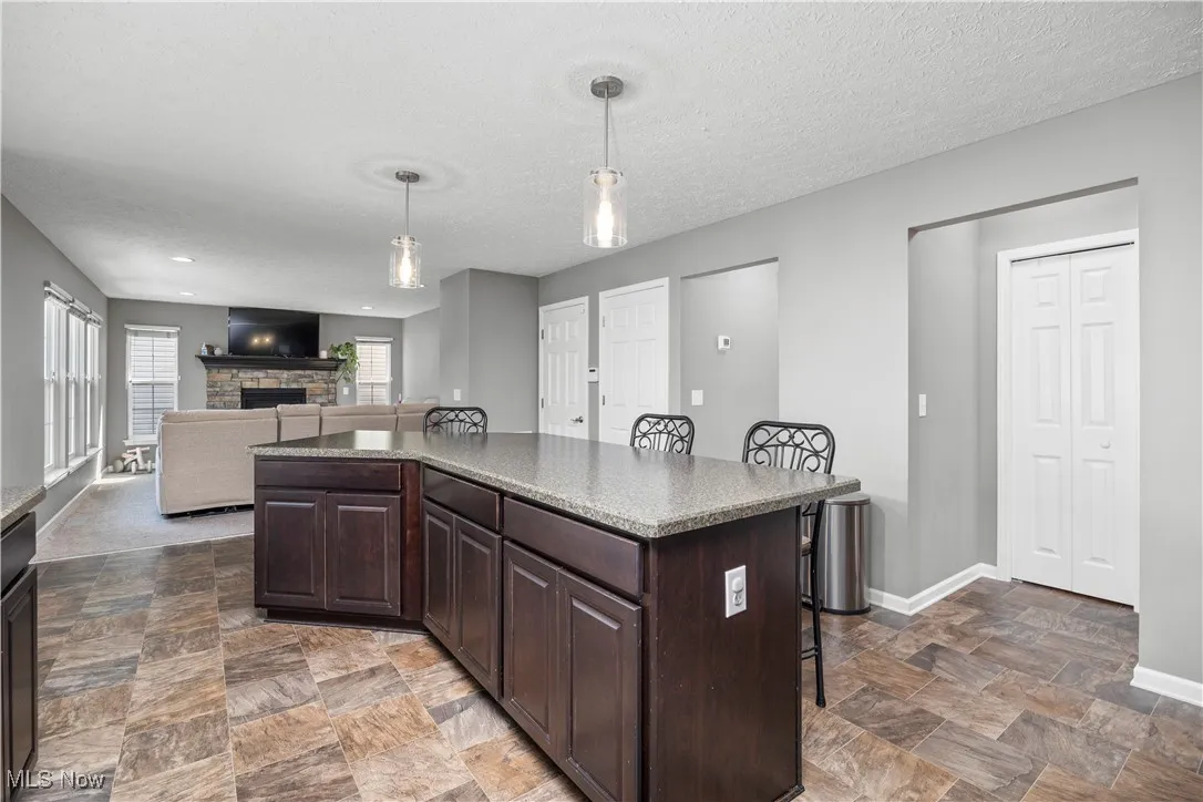 Kitchen with black appliances, breakfast bar, kitchen island, and a peninsula with another eating area view faces living room overlooking the Island and breakfast bar