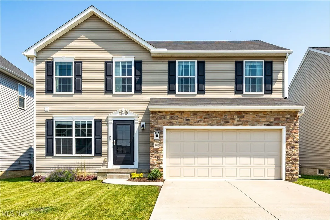 Front view of home featuring a stone veneer over garage concrete driveway and a two car garage