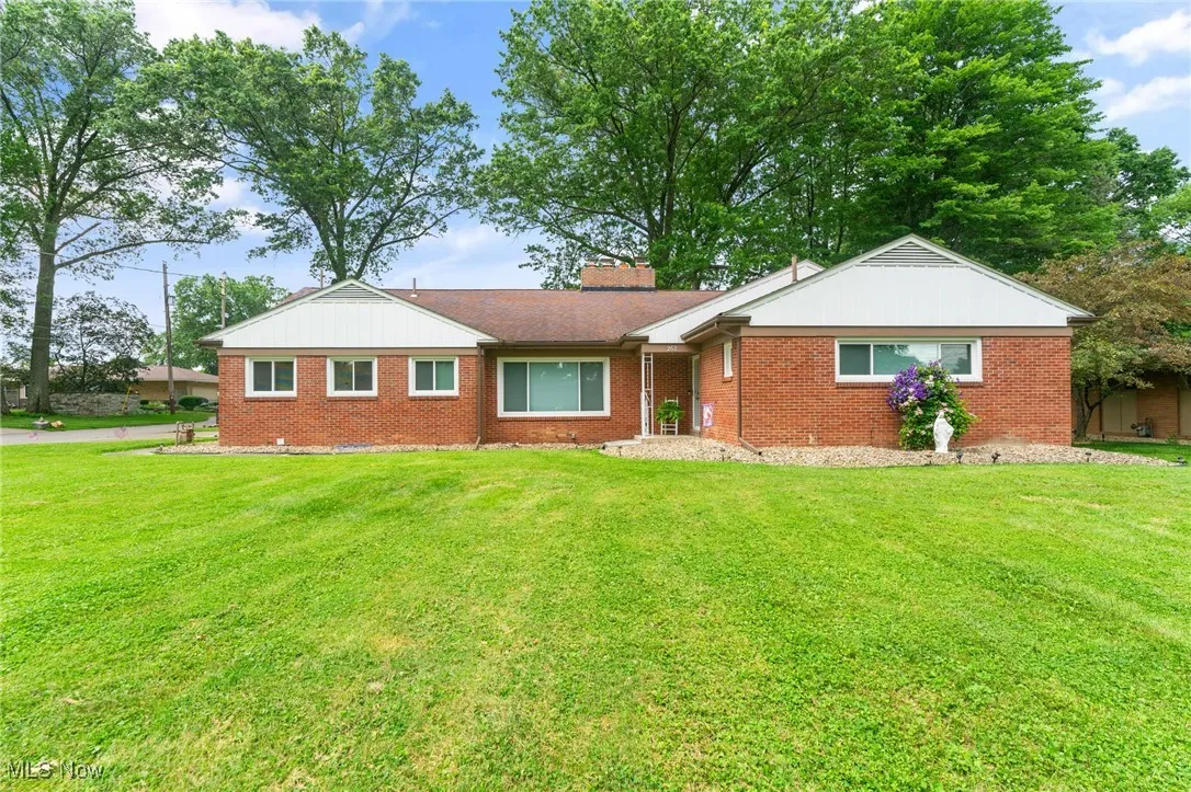 Single story home featuring brick siding, a front lawn, and a chimney