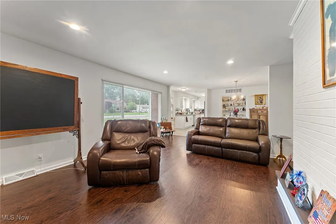 Living room featuring a chandelier, dark wood-style floors, and recessed lighting