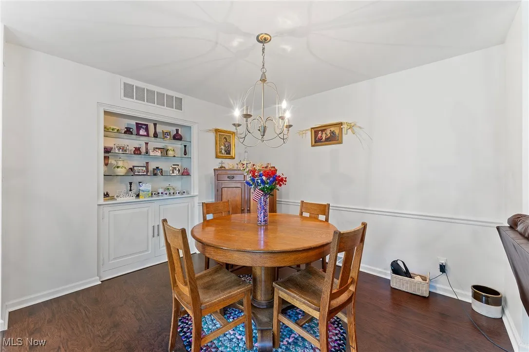 Dining area featuring a chandelier and dark wood finished floors