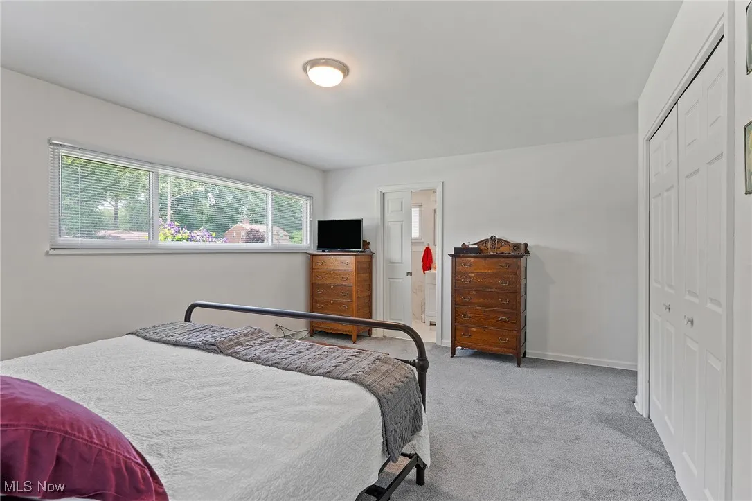 Bedroom with carpet and a closet and full bath.