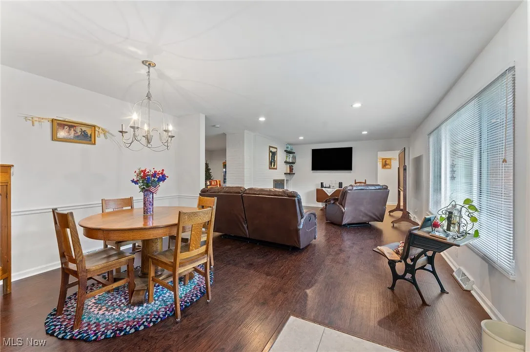 Dining area featuring dark wood-type flooring, a chandelier, and recessed lighting