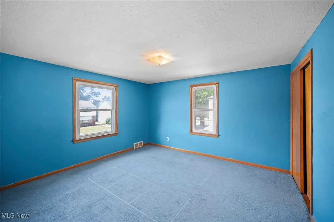 Unfurnished bedroom featuring a textured ceiling and carpet