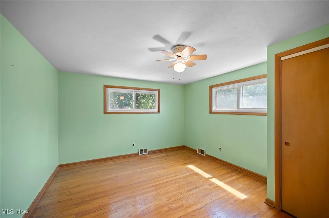 Unfurnished bedroom featuring light wood finished floors, ceiling fan, and a closet