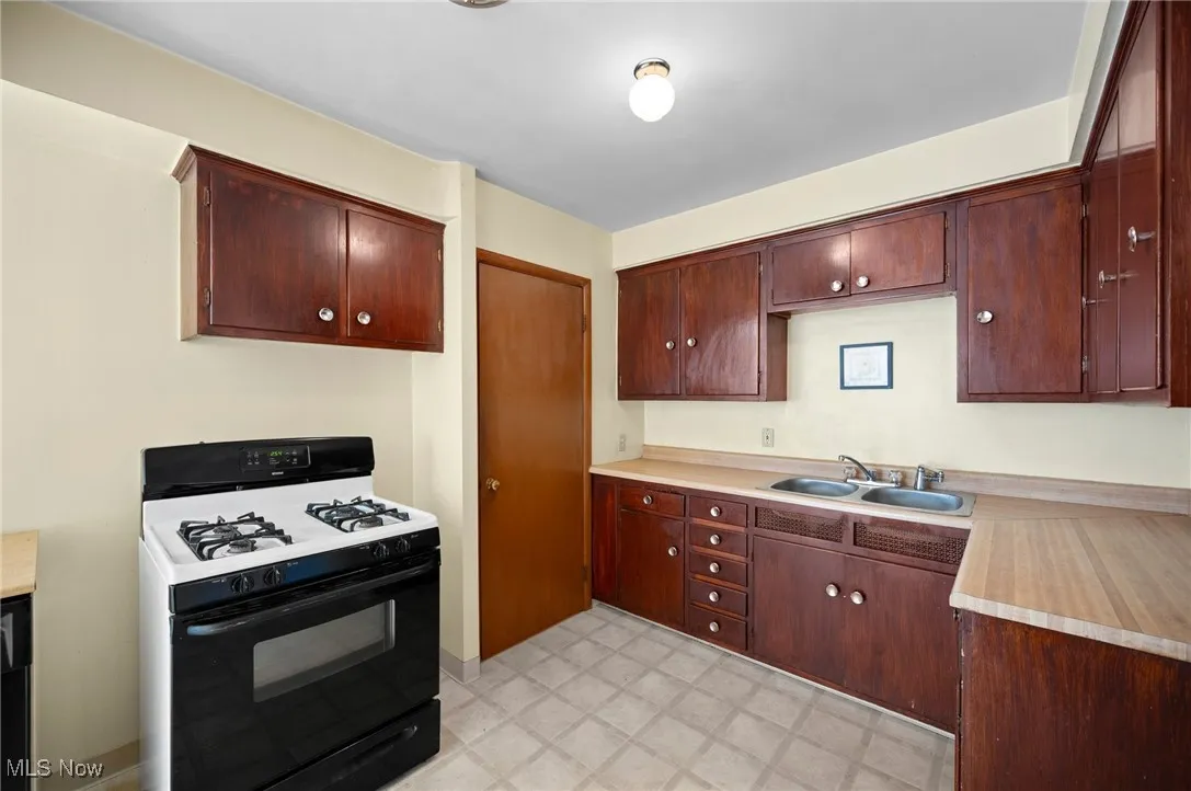Kitchen with gas range gas stove, light countertops, and light flooring