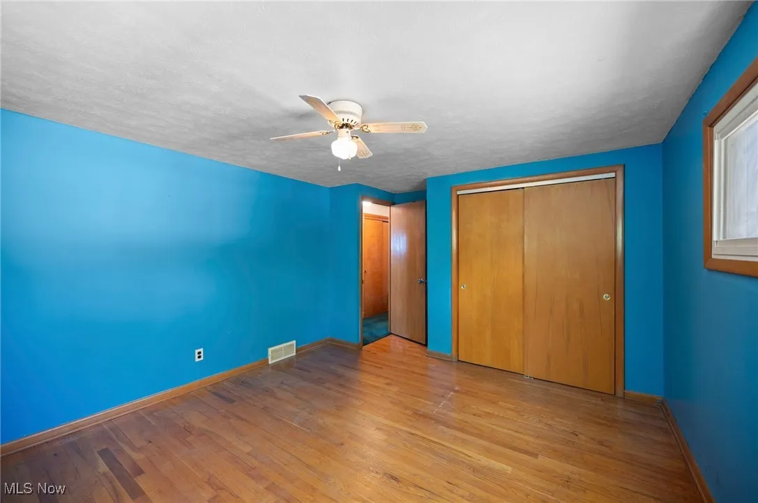 Unfurnished bedroom with wood finished floors, a ceiling fan, a textured ceiling, and a closet