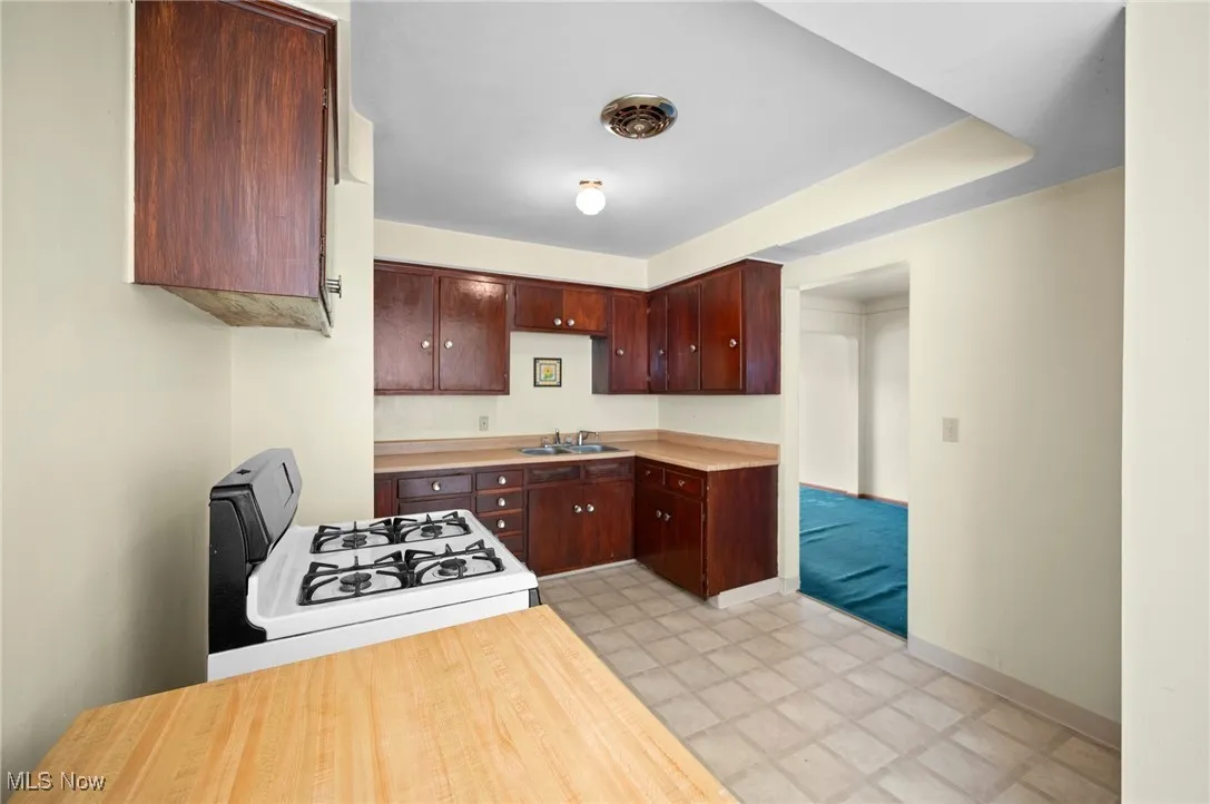 Kitchen with gas range gas stove, light floors, and light countertops