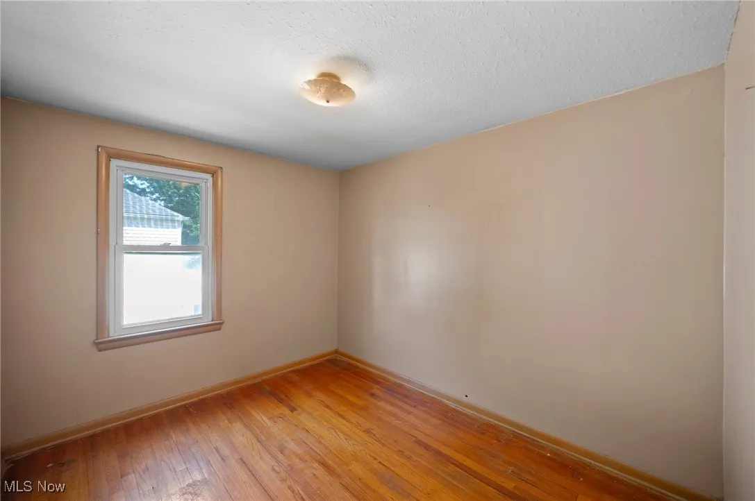 Unfurnished bedroom with light wood finished floors and a textured ceiling