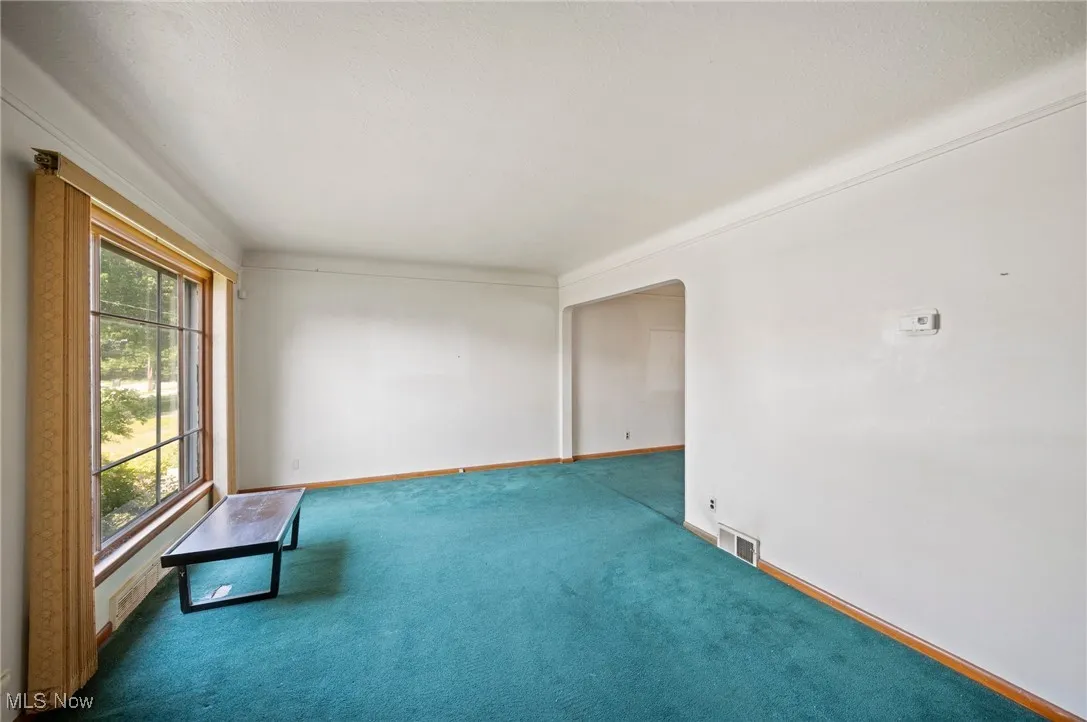 Living room with carpet flooring and arched walkways