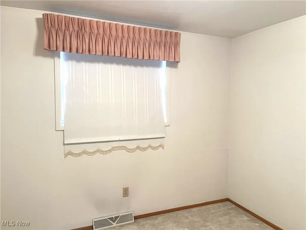 Carpeted spare room with baseboards