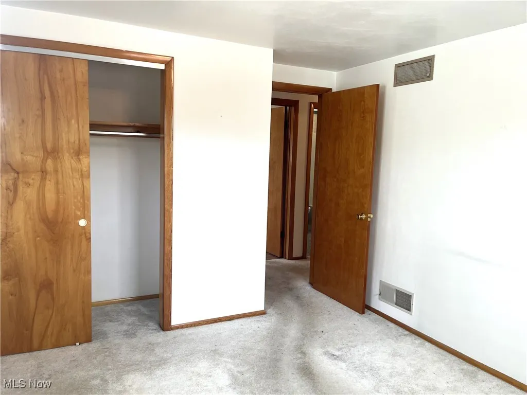 Unfurnished bedroom featuring a closet and carpet