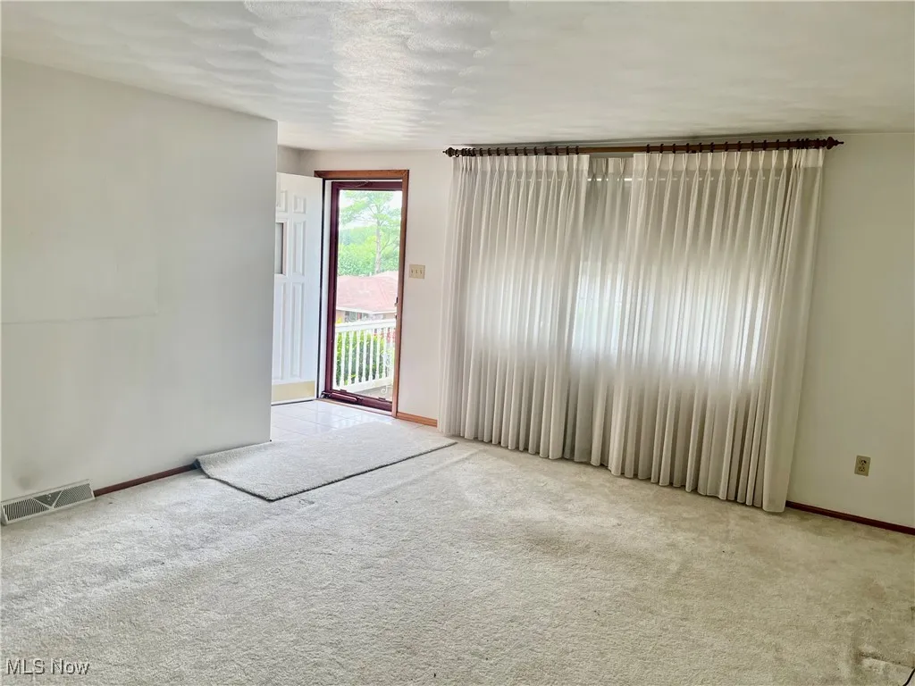 Carpeted empty room with baseboards