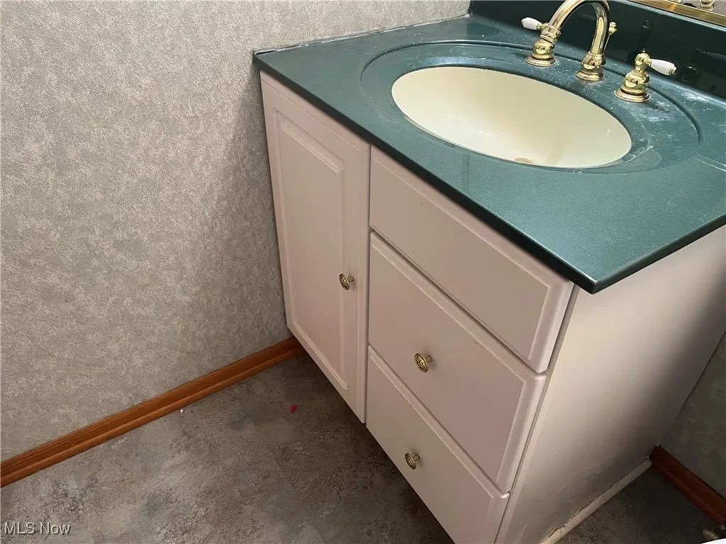 Bathroom view of baseboards and vanity