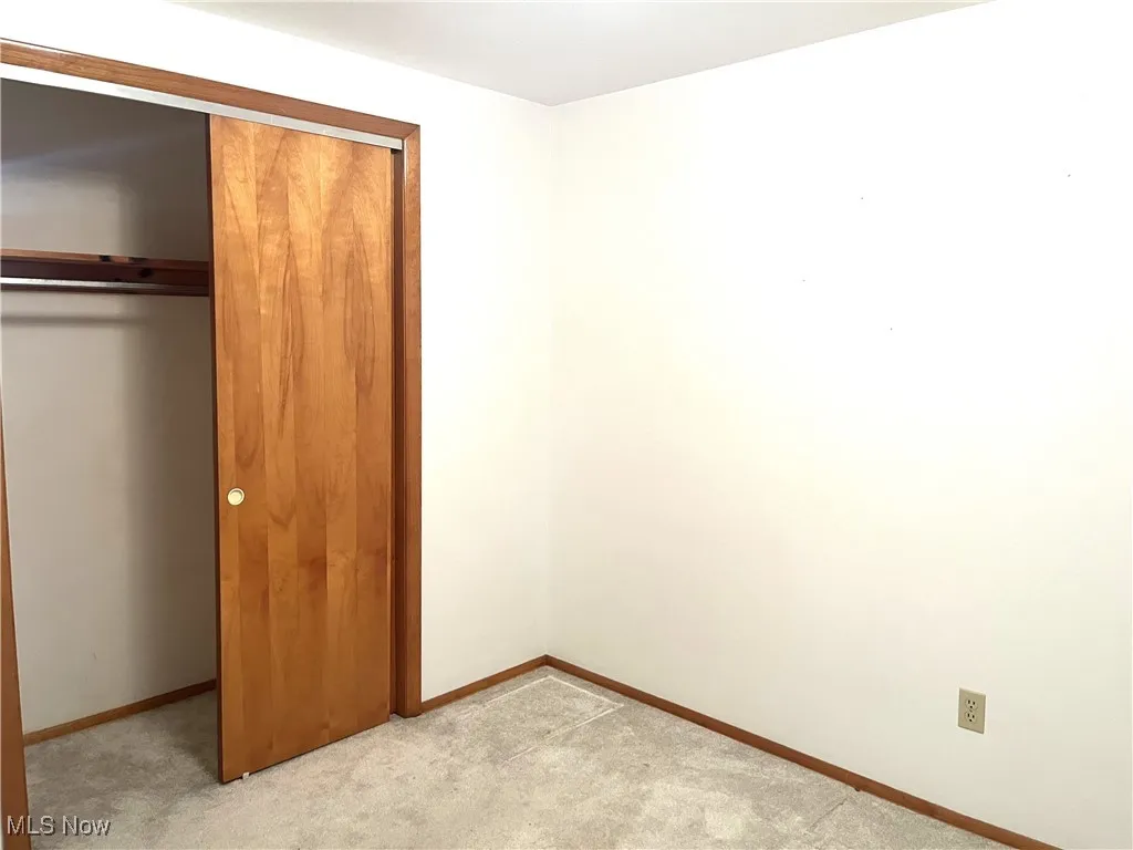Unfurnished bedroom with a closet and light colored carpet