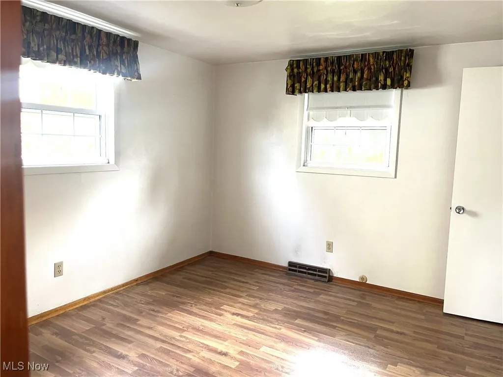 Spare room featuring wood finished floors and baseboards