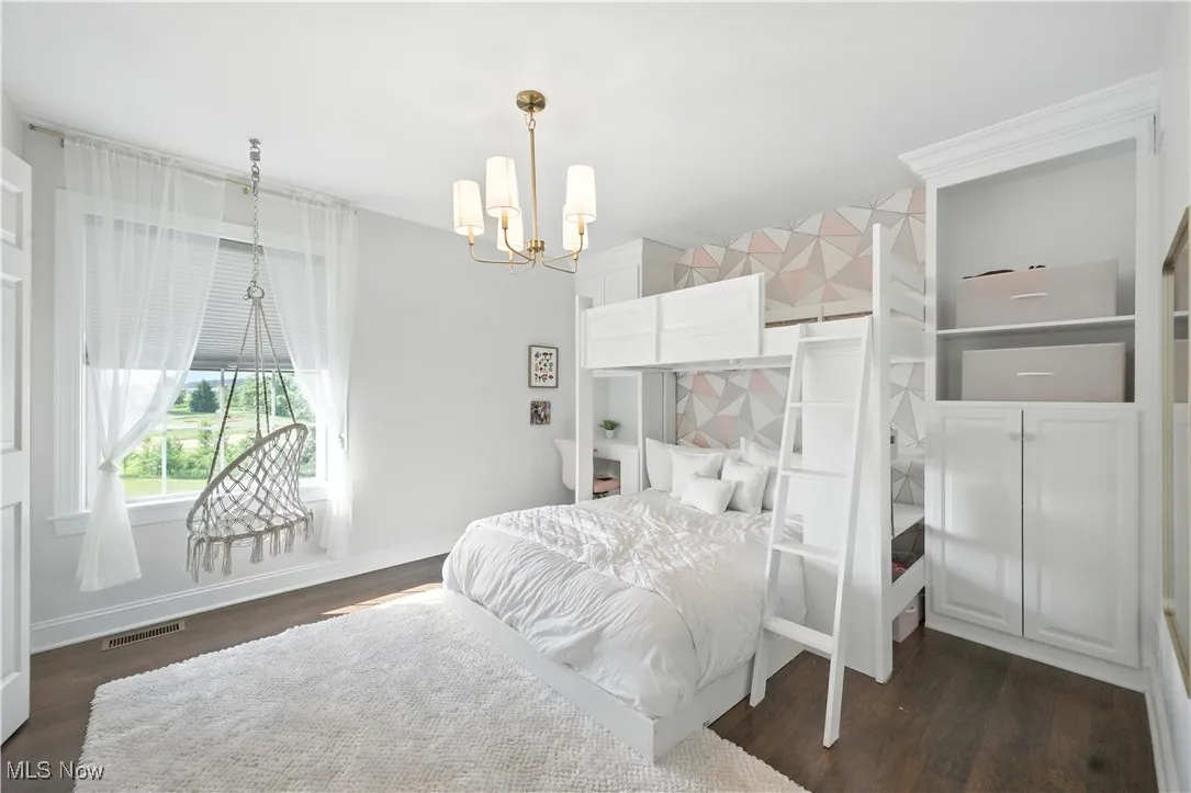 Bedroom featuring a chandelier and dark wood finished floors