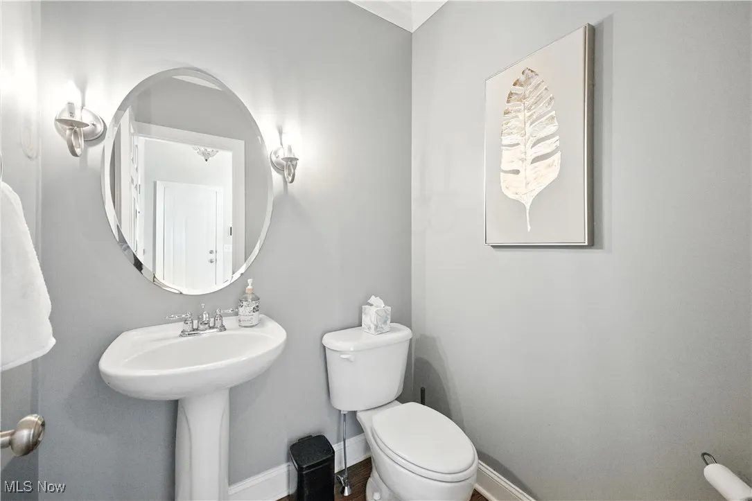 Half bathroom featuring toilet and baseboards