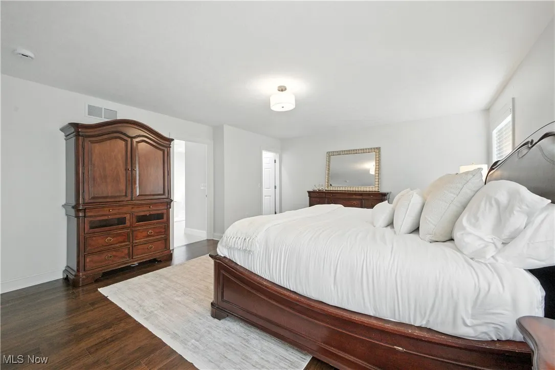 Bedroom with baseboards and dark wood-type flooring