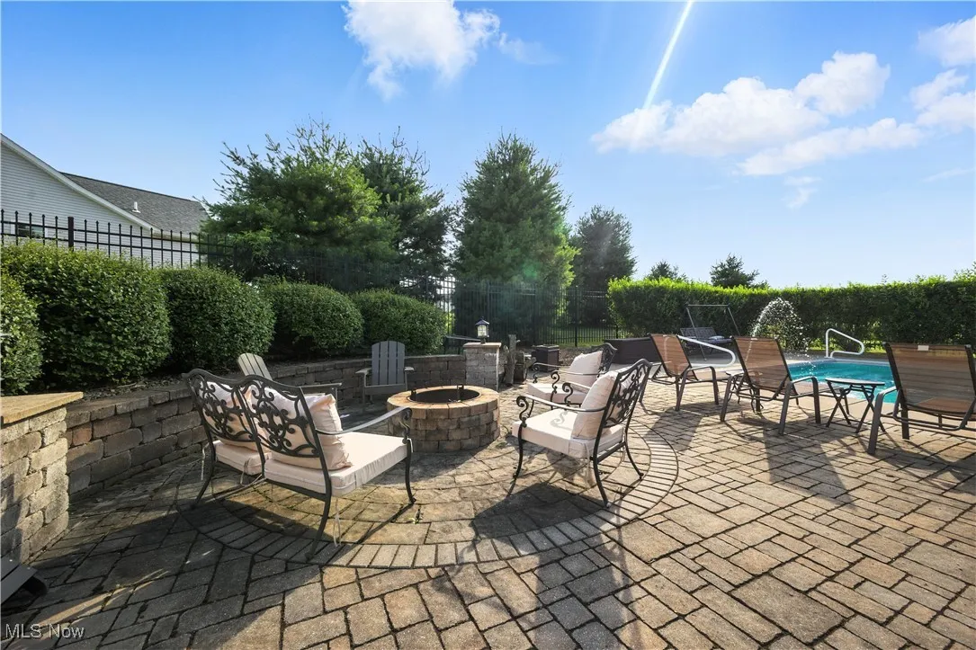 View of patio featuring an outdoor fire pit. LED lights surround for nighttime.