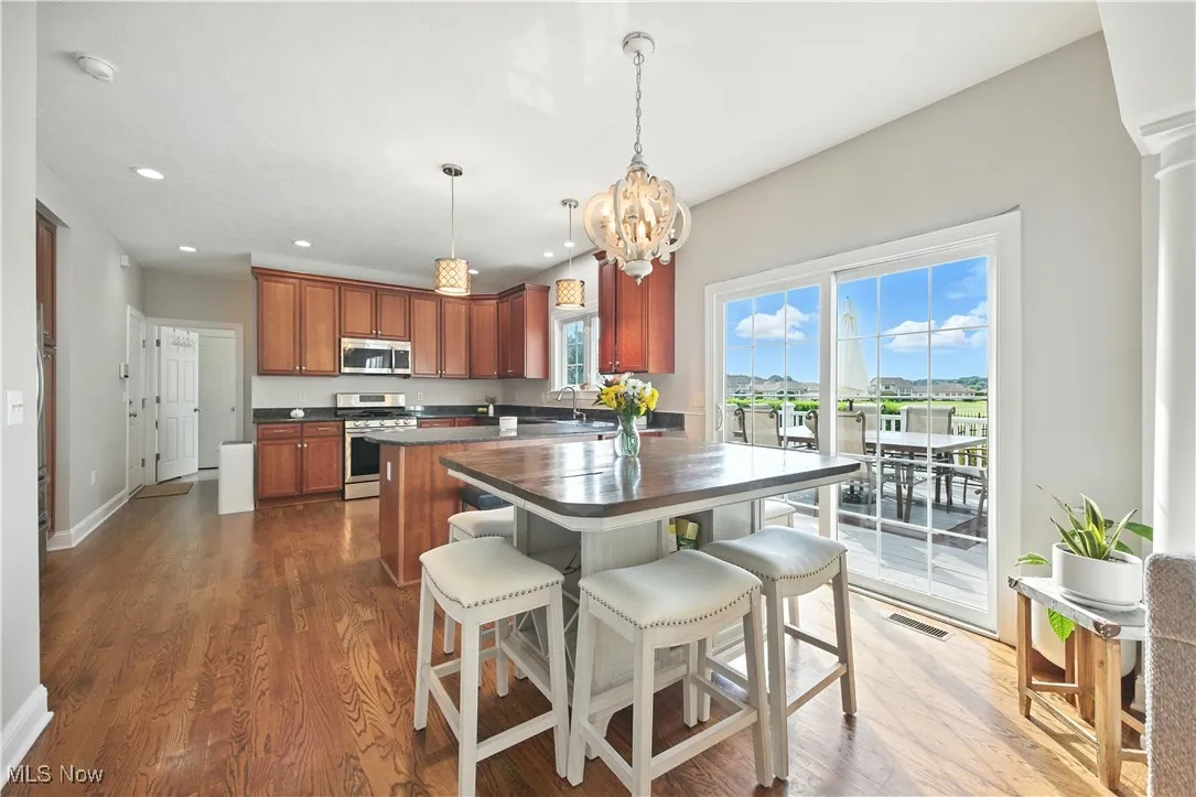 Kitchen featuring appliances with stainless steel finishes, dark countertops, recessed lighting, a chandelier, and a center island