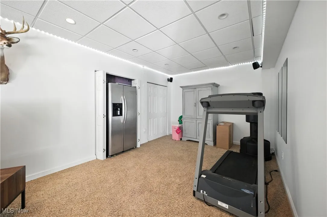 Exercise room featuring light carpet, a drop ceiling, and recessed lighting