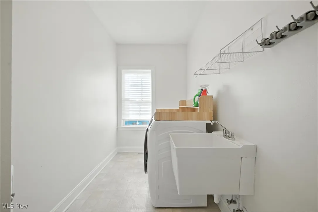 Laundry area with baseboards and washer and clothes dryer