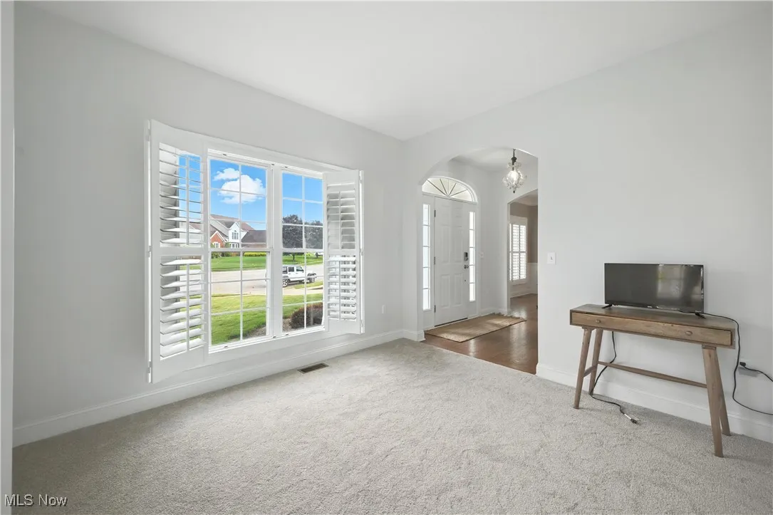 Entryway with carpet flooring, arched walkways, and a​​‌​​​​‌​​‌‌​‌‌​​​‌‌​‌​‌​‌​​​‌​​ chandelier