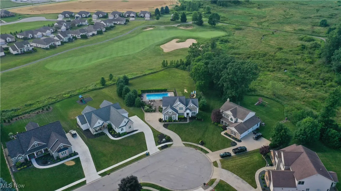 Aerial overview of property's location with nearby suburban area and a golf club