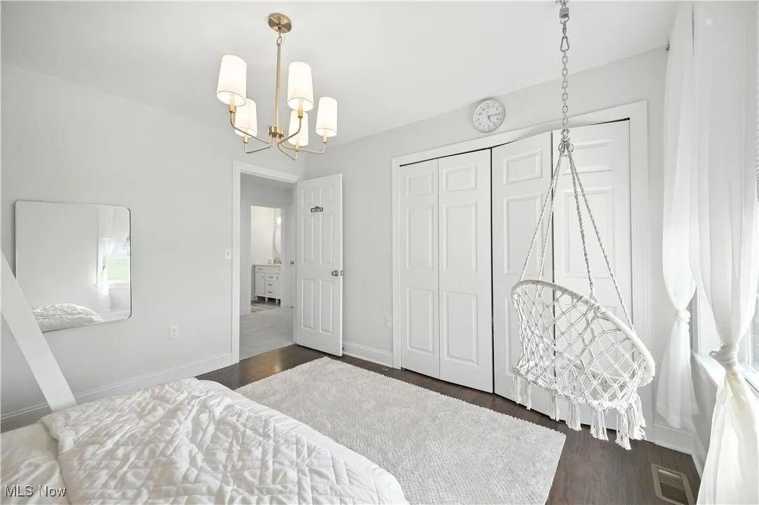 Bedroom featuring a chandelier, wood finished floors, and a closet